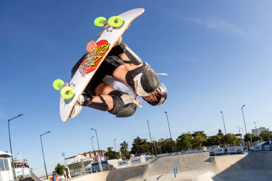 Ana Aguiar executando manobra aérea de skate em pista bowl ao ar livre